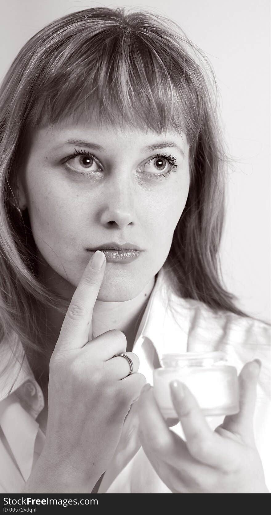 A nice girl in white shirt with cream for make-up. A nice girl in white shirt with cream for make-up