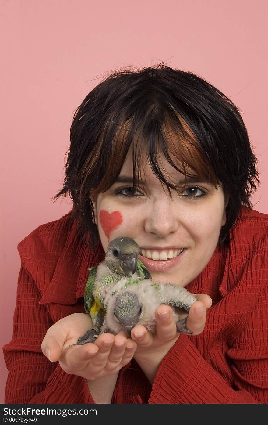 Beautiful woman holding two baby parrot