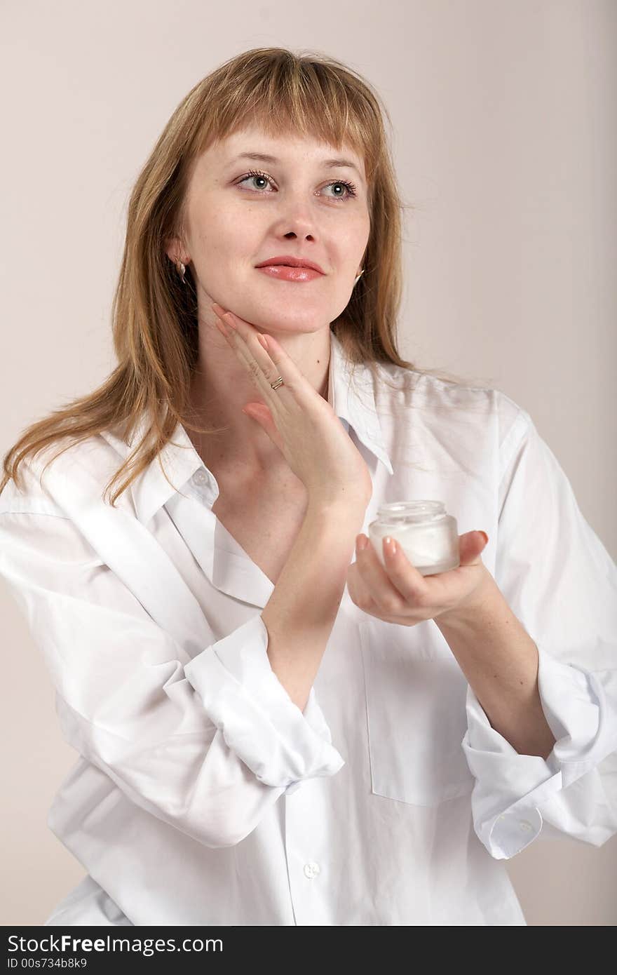 A woman in white shirt with cream for make-up