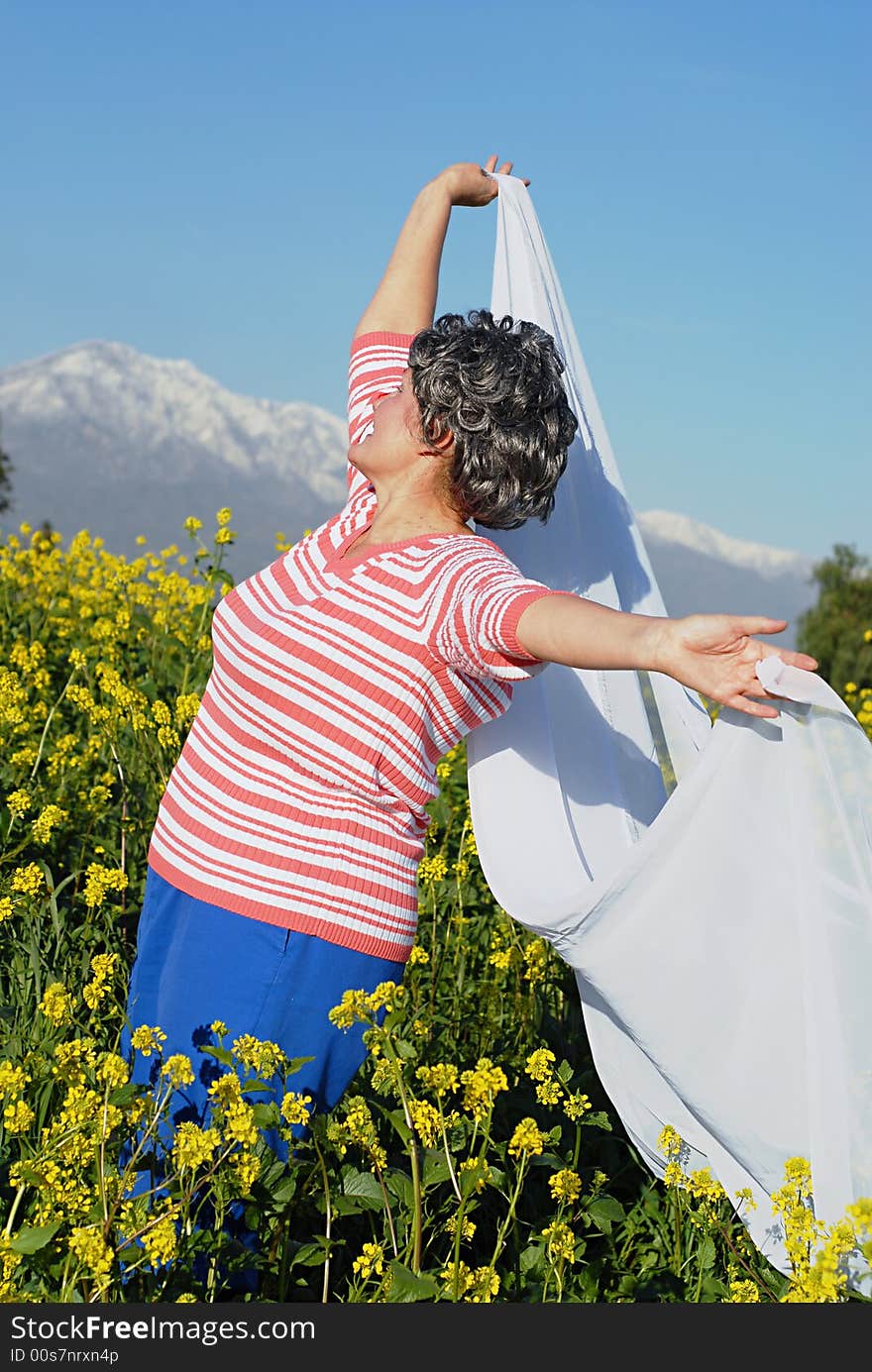 Attractive older woman enjoying the fresh mountain air. Attractive older woman enjoying the fresh mountain air