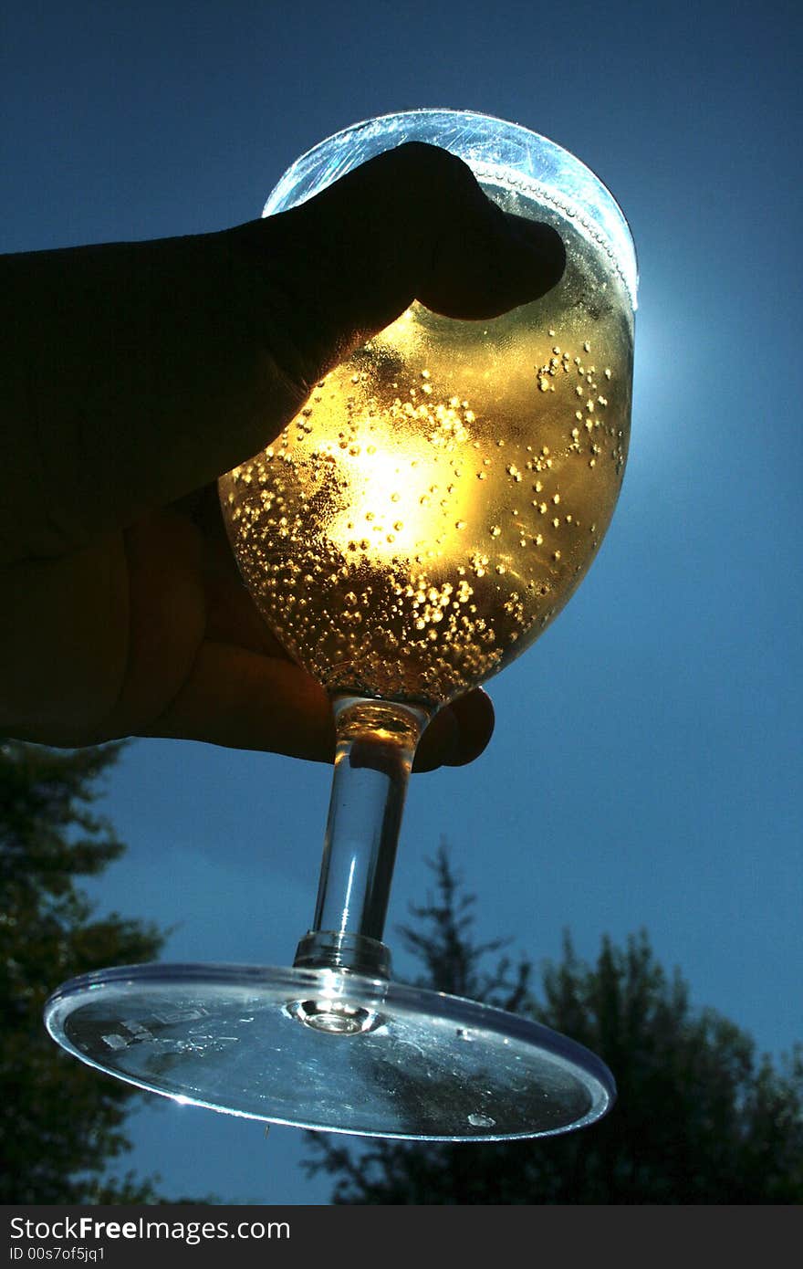 A person holding a glass illuminated