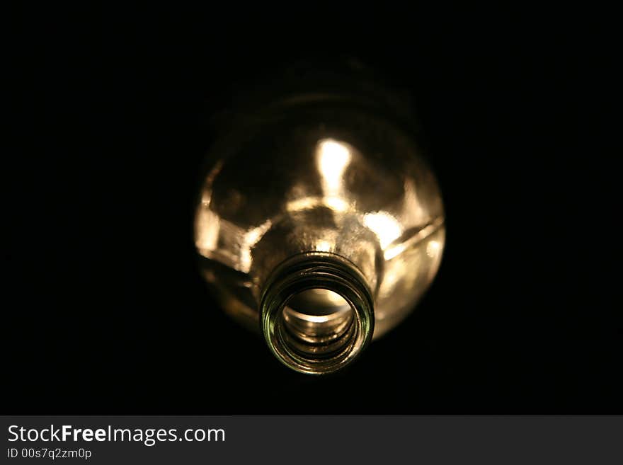 Empty glass bottle lying in the dark with spooky light. Empty glass bottle lying in the dark with spooky light