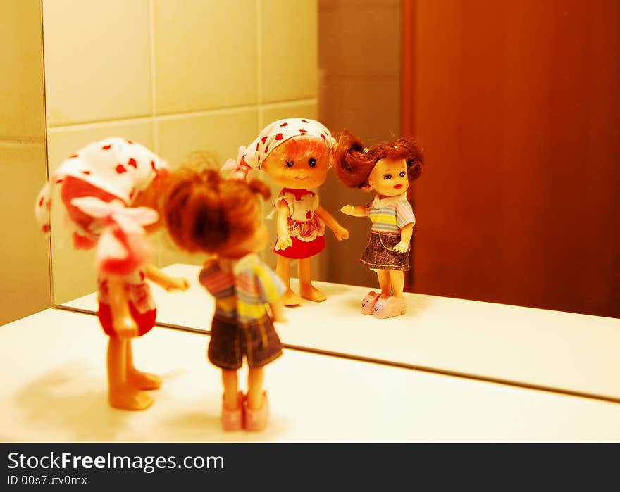 2 dolls in front of a mirror, with colorful clothers