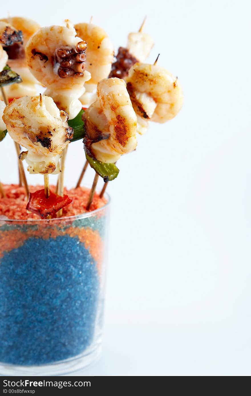 Shrimp skewers covered in a glass of colored salts. Shrimp skewers covered in a glass of colored salts