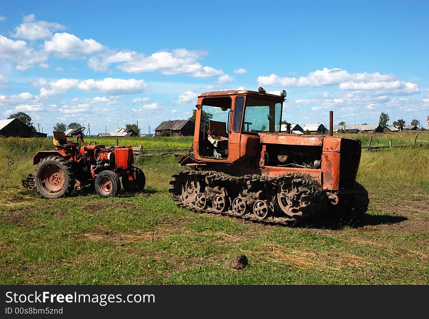 Two old tractors on the meadow at dinner-time. Two old tractors on the meadow at dinner-time