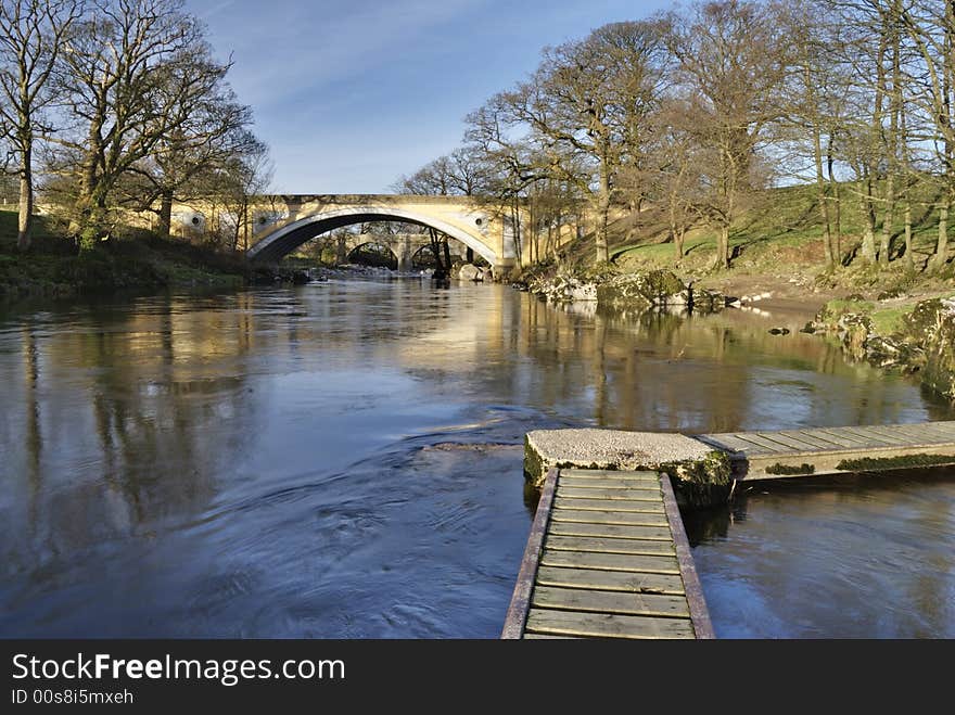 The medieval Devils bridge seen through the modern road gridge on the river Lune near Kirkby Lonsdale, Cumbria, UK. The medieval Devils bridge seen through the modern road gridge on the river Lune near Kirkby Lonsdale, Cumbria, UK