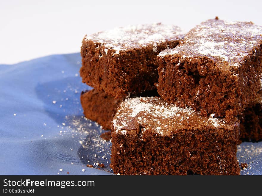 Thick chocolate fudge brownies with powdered sugar sprinkled on top.