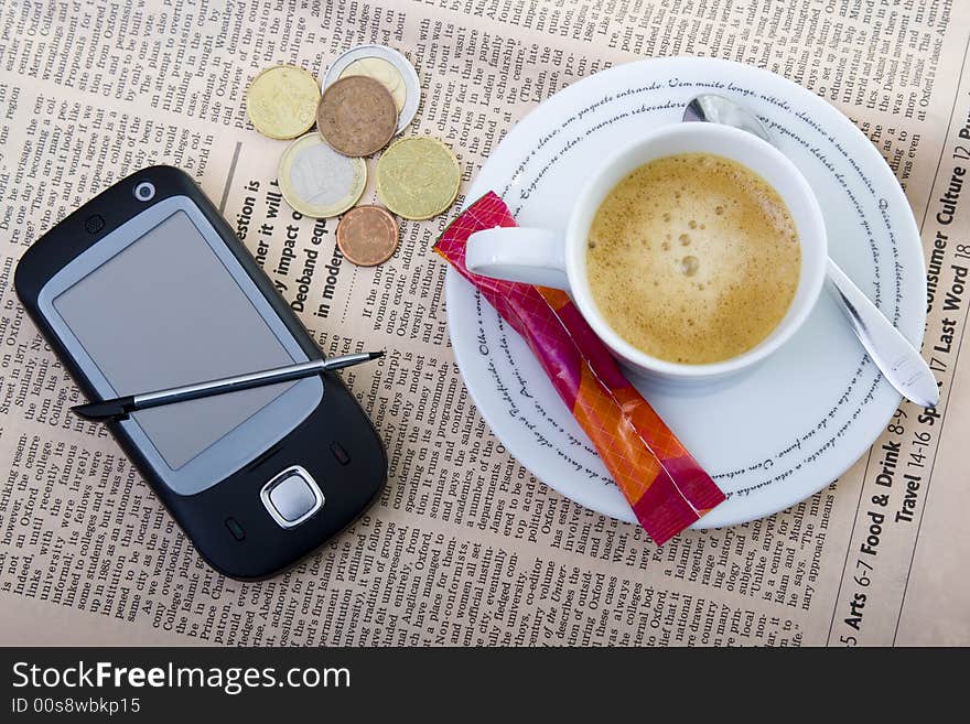 Cellphone, money and coffee over newspaper -business concept