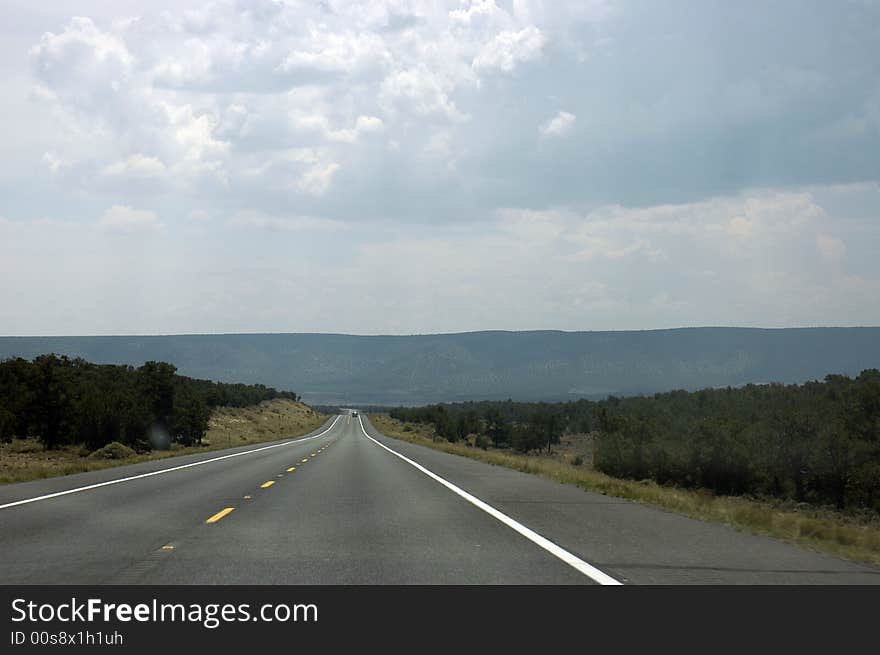 A Mid-west USA road taking me to the mountains in the middle of the vegetation. A Mid-west USA road taking me to the mountains in the middle of the vegetation