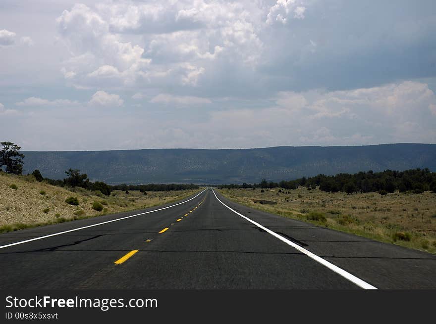 A Mid-west USA road taking me to the mountains in the middle of the vegetation. A Mid-west USA road taking me to the mountains in the middle of the vegetation