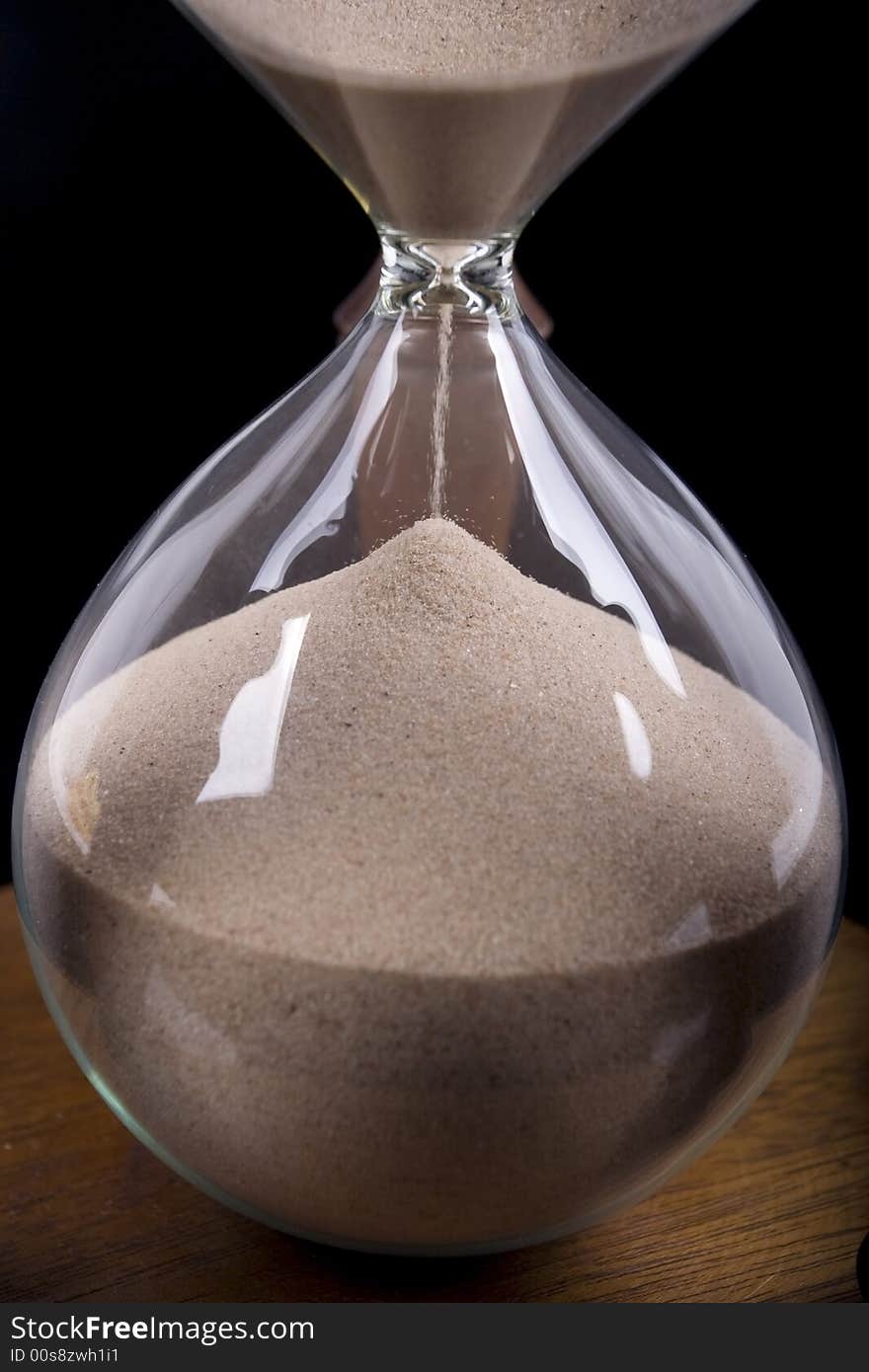 Detail of hourglass on black background. Detail of hourglass on black background