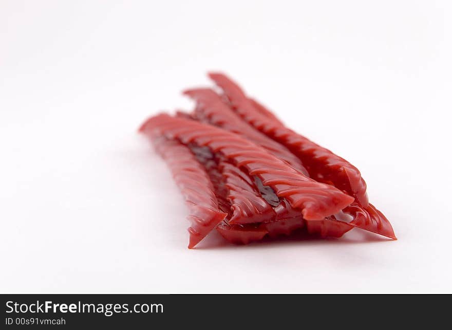 Bundle of red licorice on white background