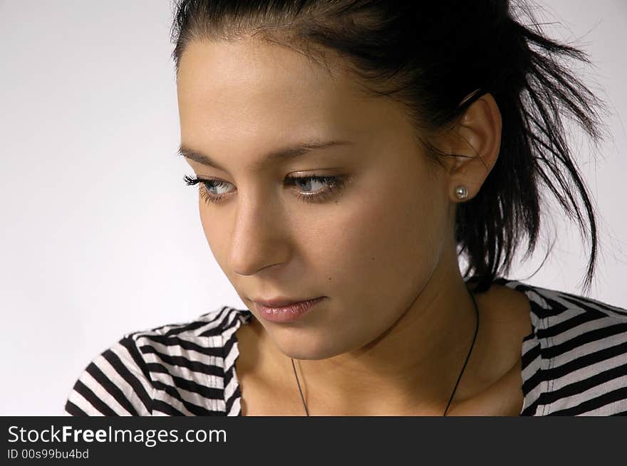 The beautiful brunette on a grey background