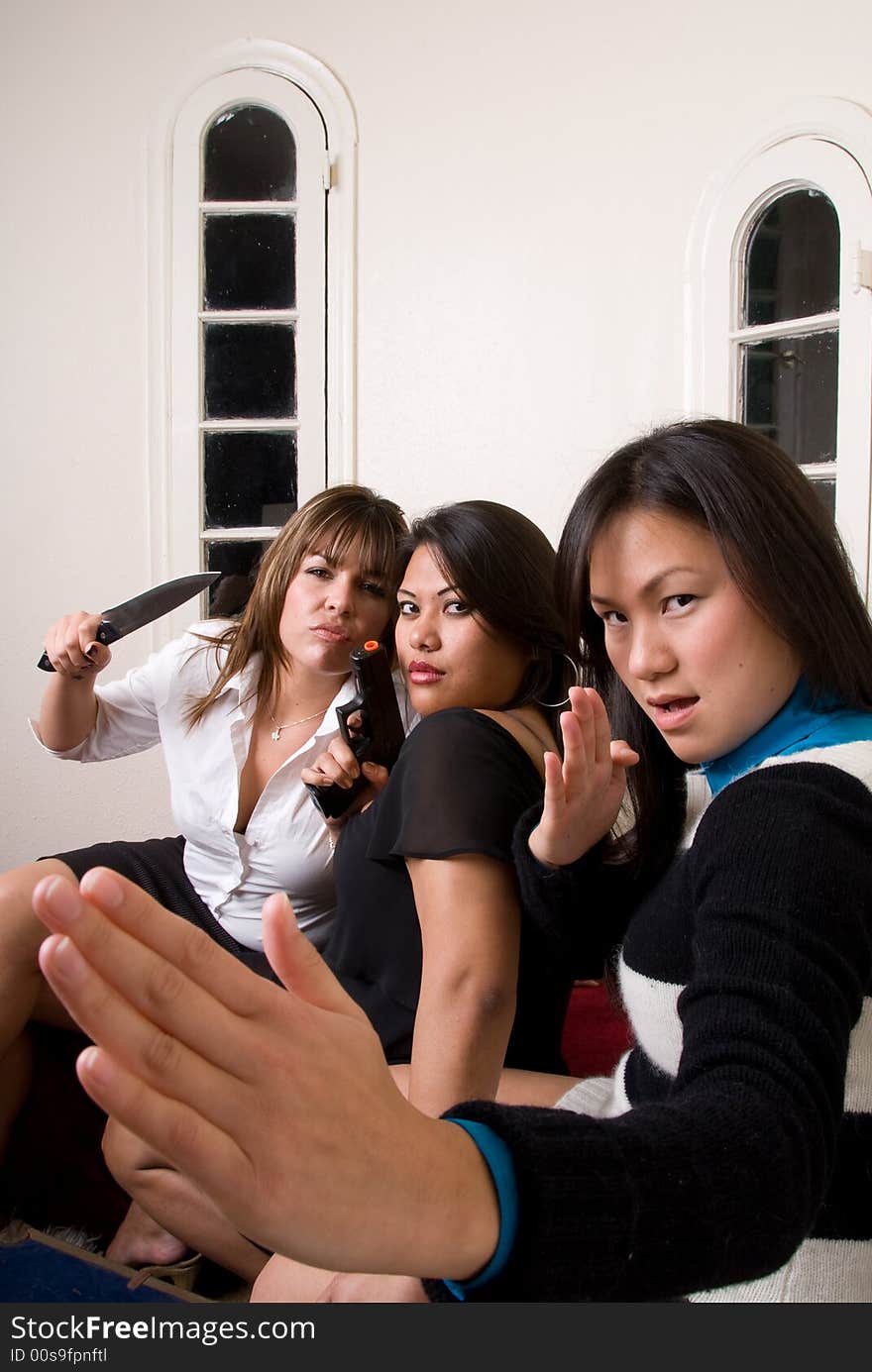 3 females with weapons in attack positions. 3 females with weapons in attack positions.