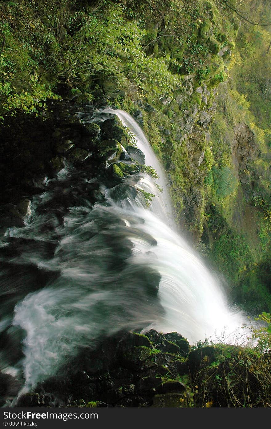 Water topples over the top of a fall. Water topples over the top of a fall