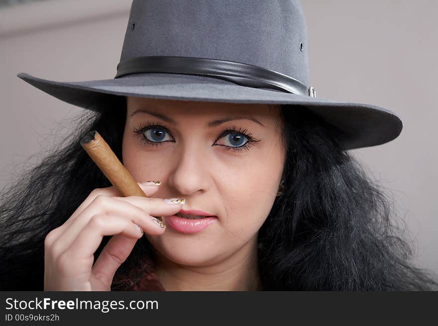 An image of a nice woman in felt hat with cigar. An image of a nice woman in felt hat with cigar