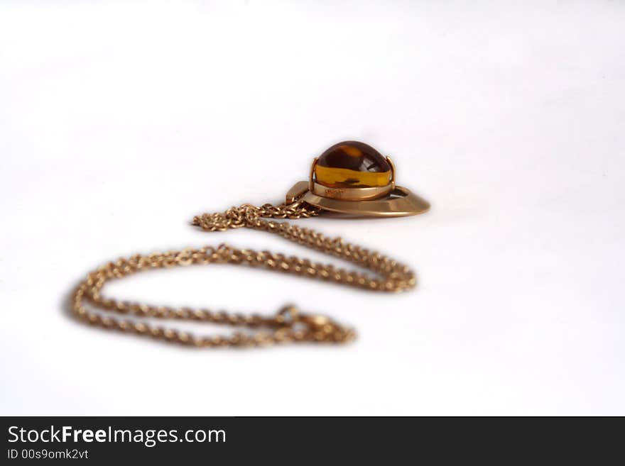 Precious gold(en) pendant with stone from amber lies