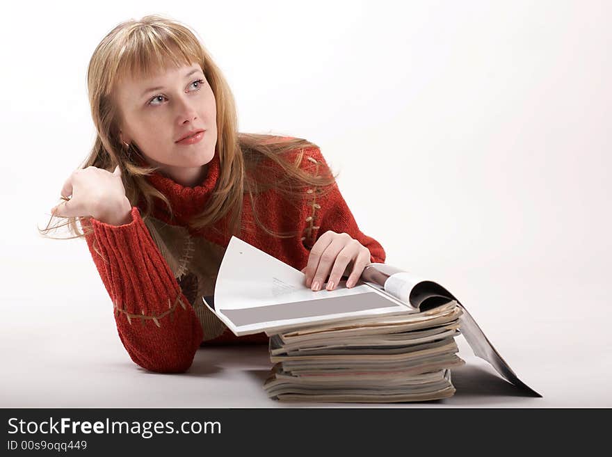 A beautiful girl luing and reading magazines