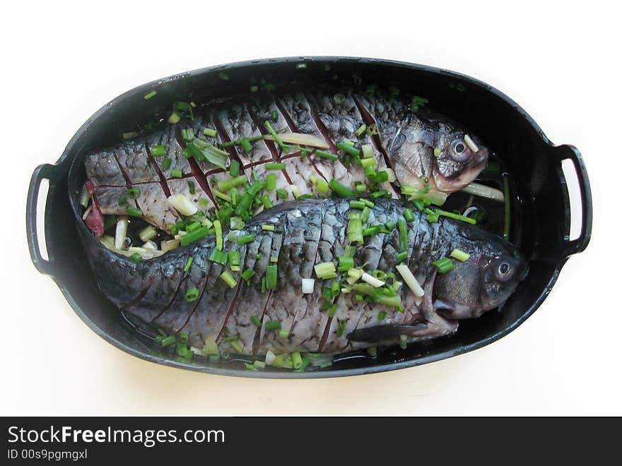 Two fish on a bowl in white ,with salt and onions. Two fish on a bowl in white ,with salt and onions