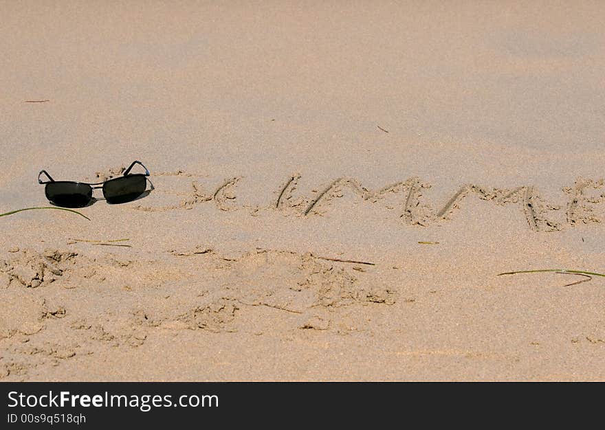 Sand writing on the beach with sunglasses. Sand writing on the beach with sunglasses