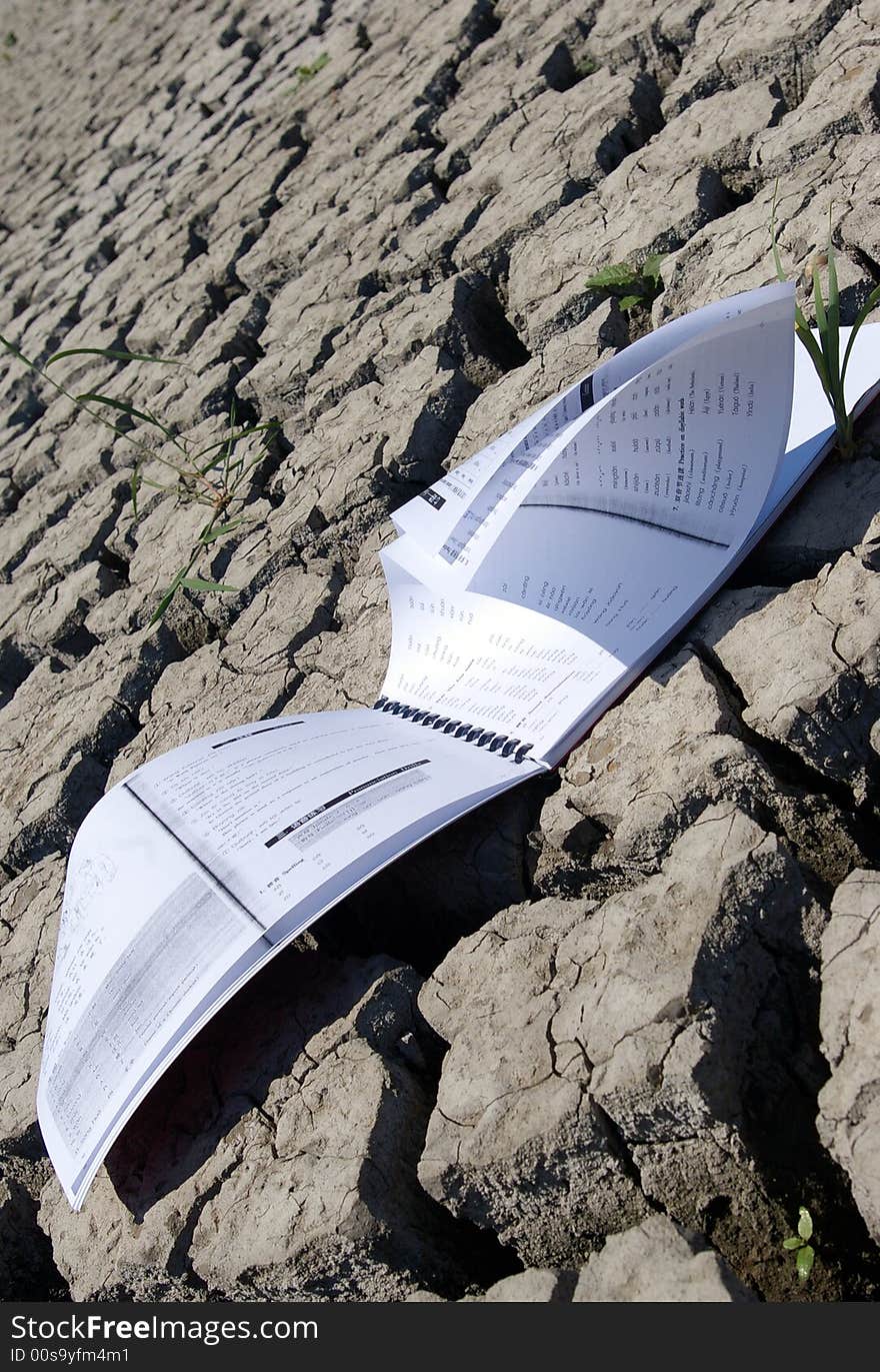 A book on a cracked land surface. A book on a cracked land surface