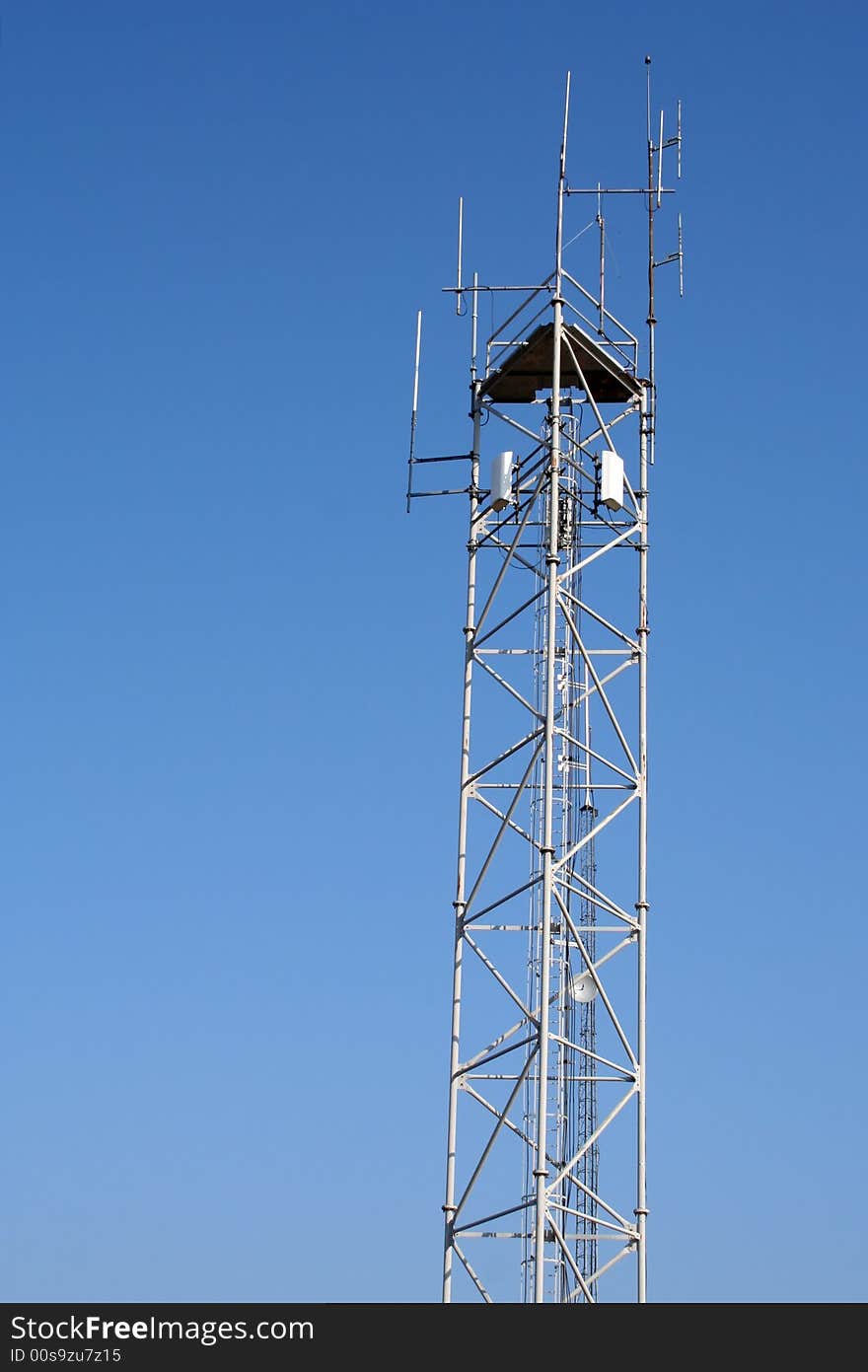 Highest part of a radio antenna with blue sky in the background.