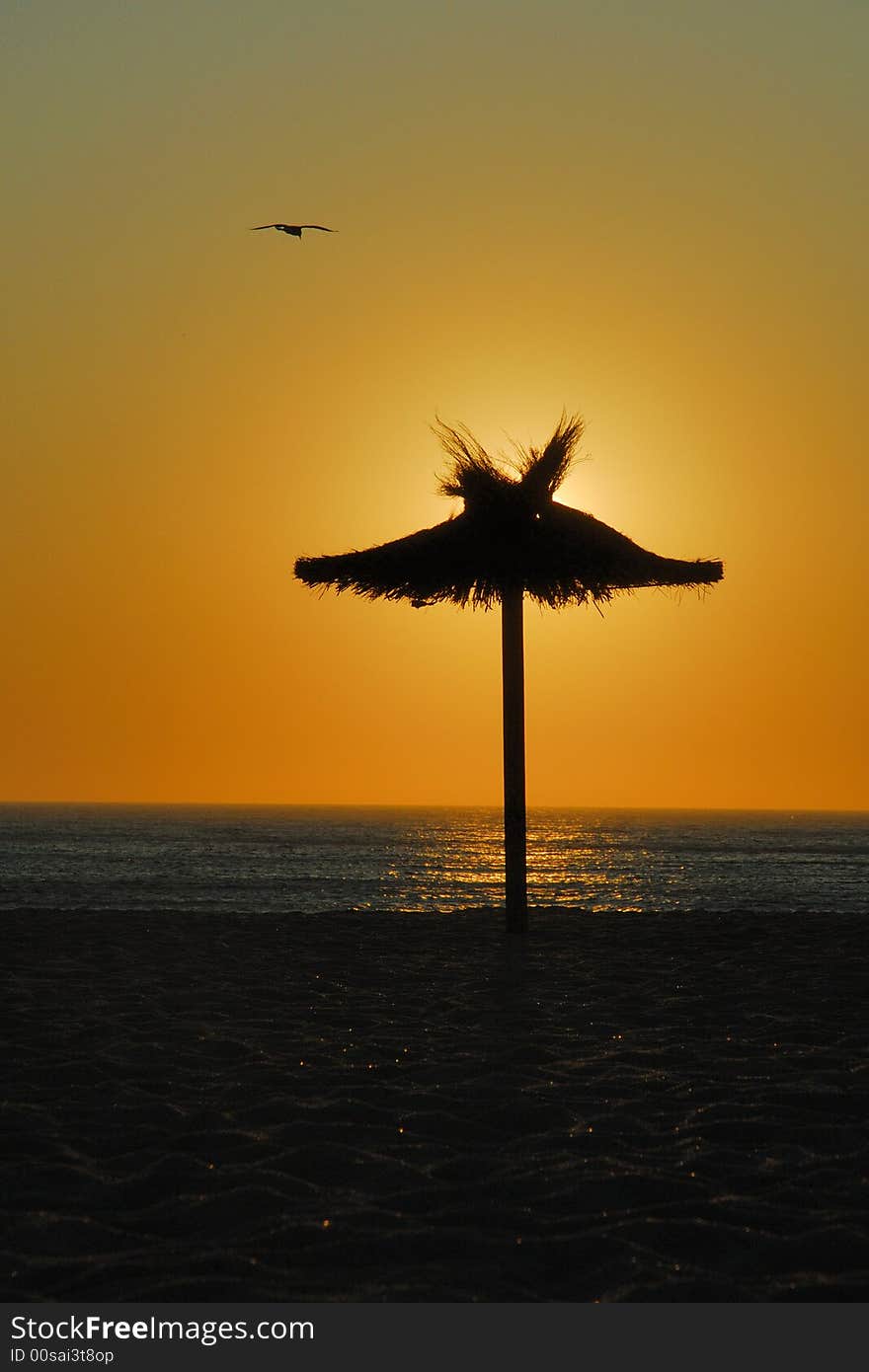 Romantic sunset on the ocean beach with Hawaii style sunshade. Romantic sunset on the ocean beach with Hawaii style sunshade