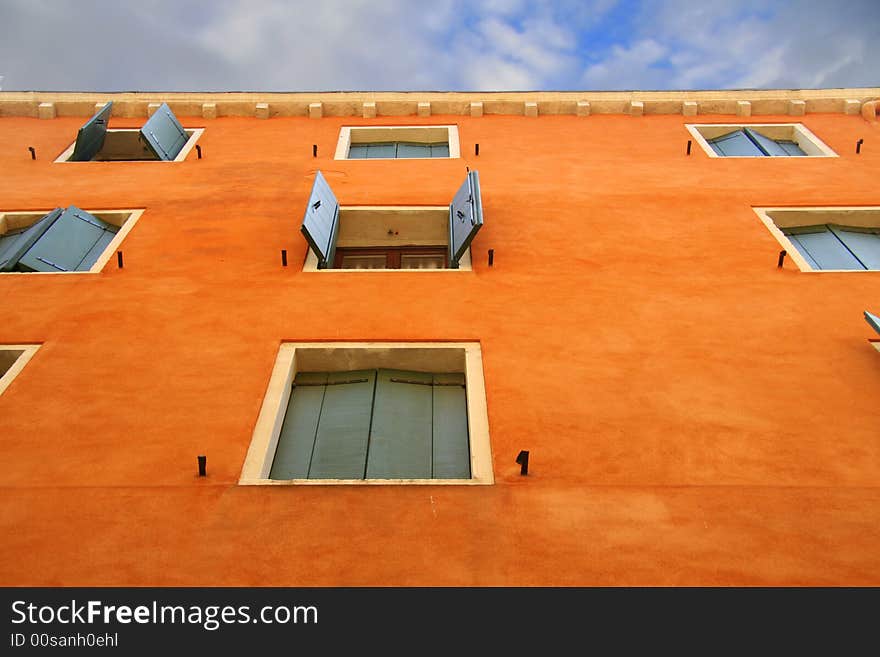 Orange Wall with open and closed green shutters in Venice. Orange Wall with open and closed green shutters in Venice