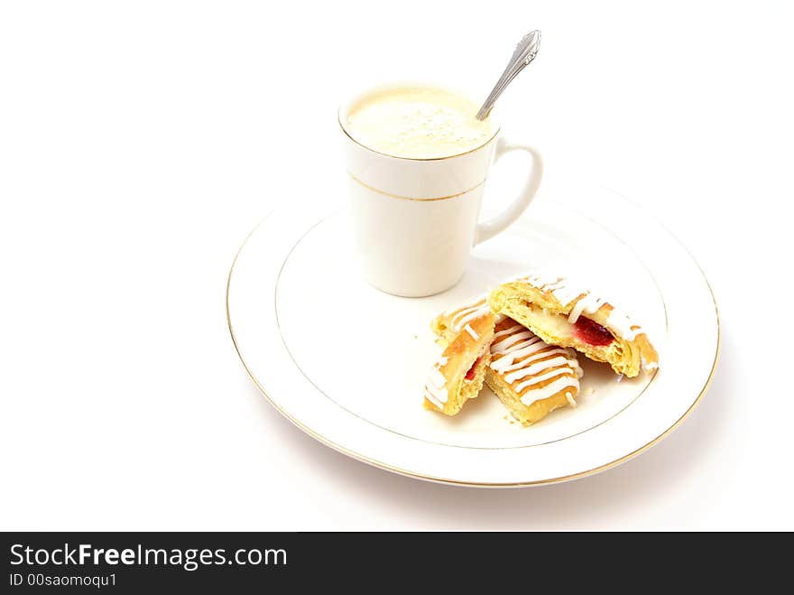 Danish pastry with strawberry and cream cheese filling, on plate next to cup of cappuccino. High key, low depth. Danish pastry with strawberry and cream cheese filling, on plate next to cup of cappuccino. High key, low depth.