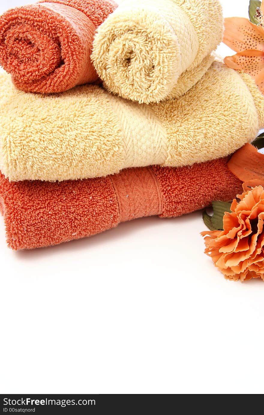 Beautiful bath ensemble with wash cloths and towels in burnt orange and sand colors on white.