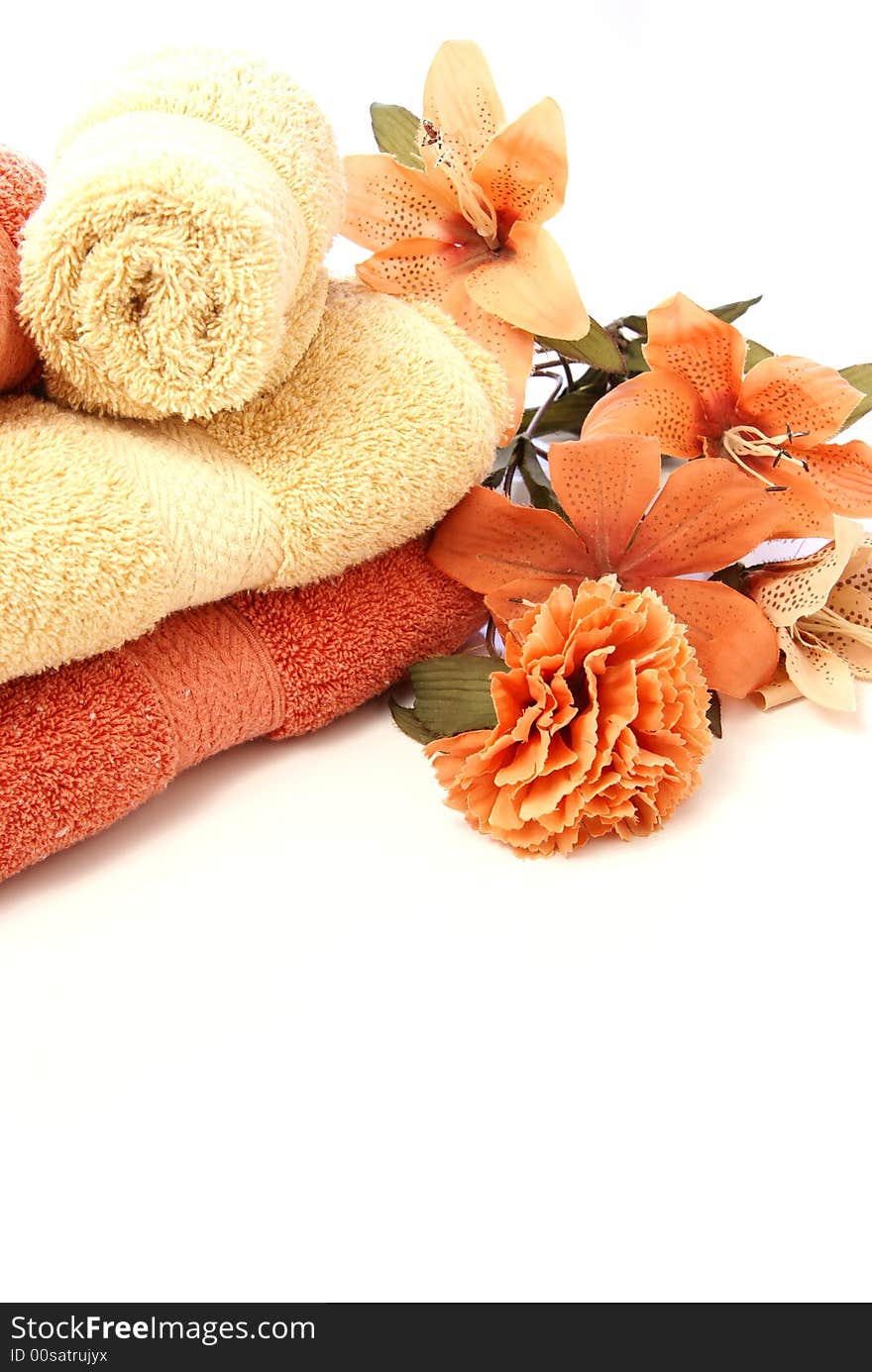 Beautiful bath ensemble with wash cloths and towels in burnt orange and sand colors on white.