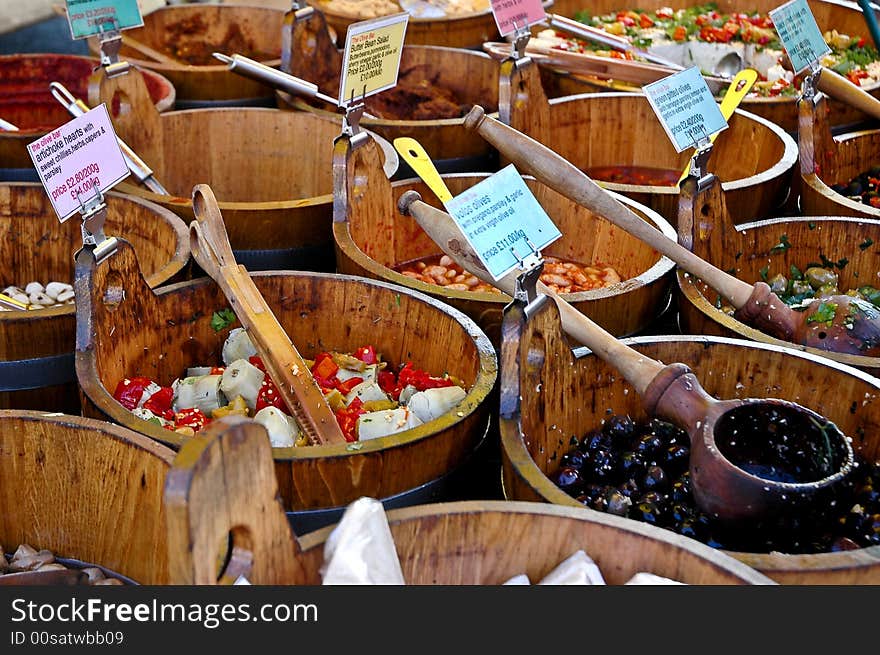 Olives for sale in wooden tubs at a market stall. Olives for sale in wooden tubs at a market stall