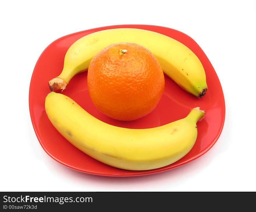 Two bananas and one orange on a plate. Two bananas and one orange on a plate