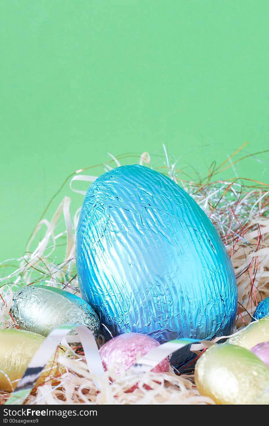 Assortment of chocolate Easter eggs wrapped in colorful paper in straw. Assortment of chocolate Easter eggs wrapped in colorful paper in straw