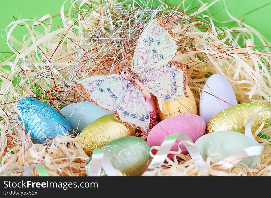 Assortment of chocolate Easter eggs wrapped in colorful paper with butterfly on top. Assortment of chocolate Easter eggs wrapped in colorful paper with butterfly on top