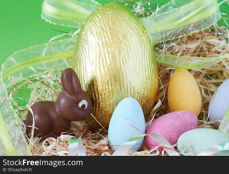 Assortment of chocolate Easter eggs wrapped in colorful paper and ribbon with edible chocolate bunny. Assortment of chocolate Easter eggs wrapped in colorful paper and ribbon with edible chocolate bunny