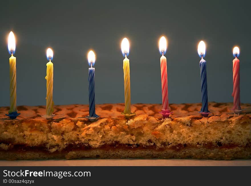 Burning color candles on a celebratory pie