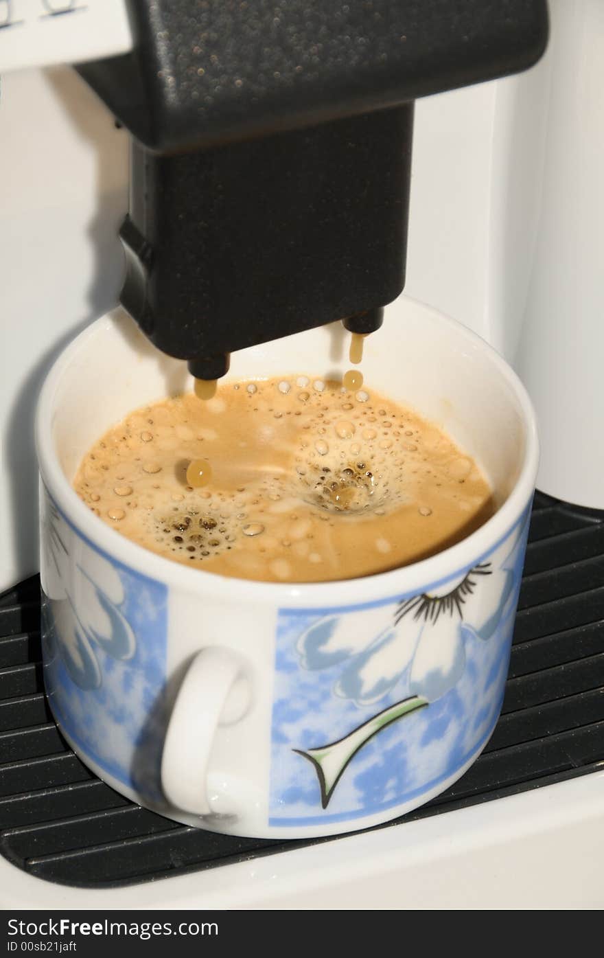 A cup at the ready in an expresso machine. A cup at the ready in an expresso machine.