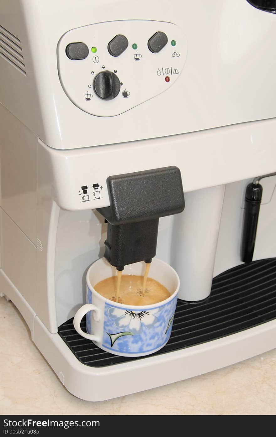 A cup at the ready in an expresso machine. A cup at the ready in an expresso machine.