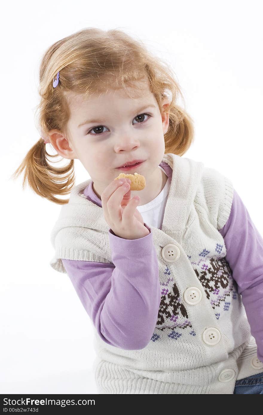 Cute little girl eating cookie