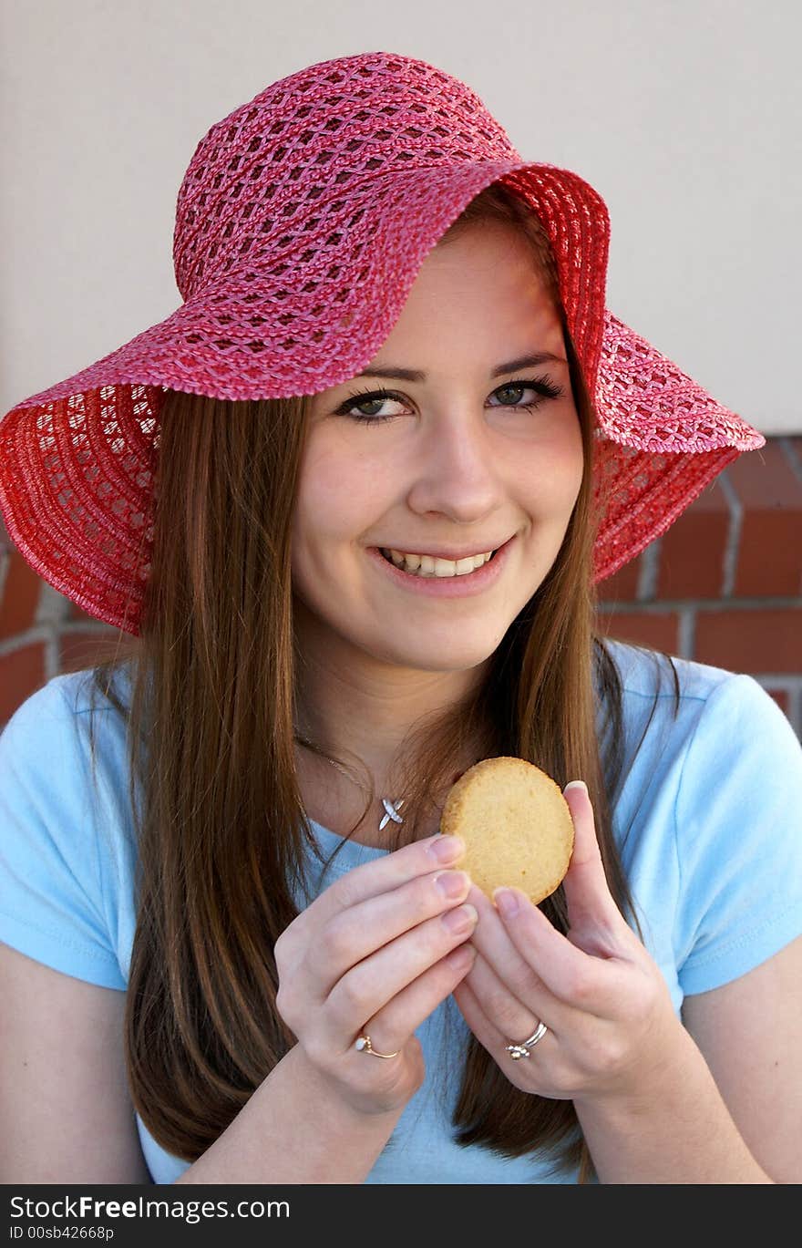 Pretty Girl Wearing Red Hat Holding Cookie