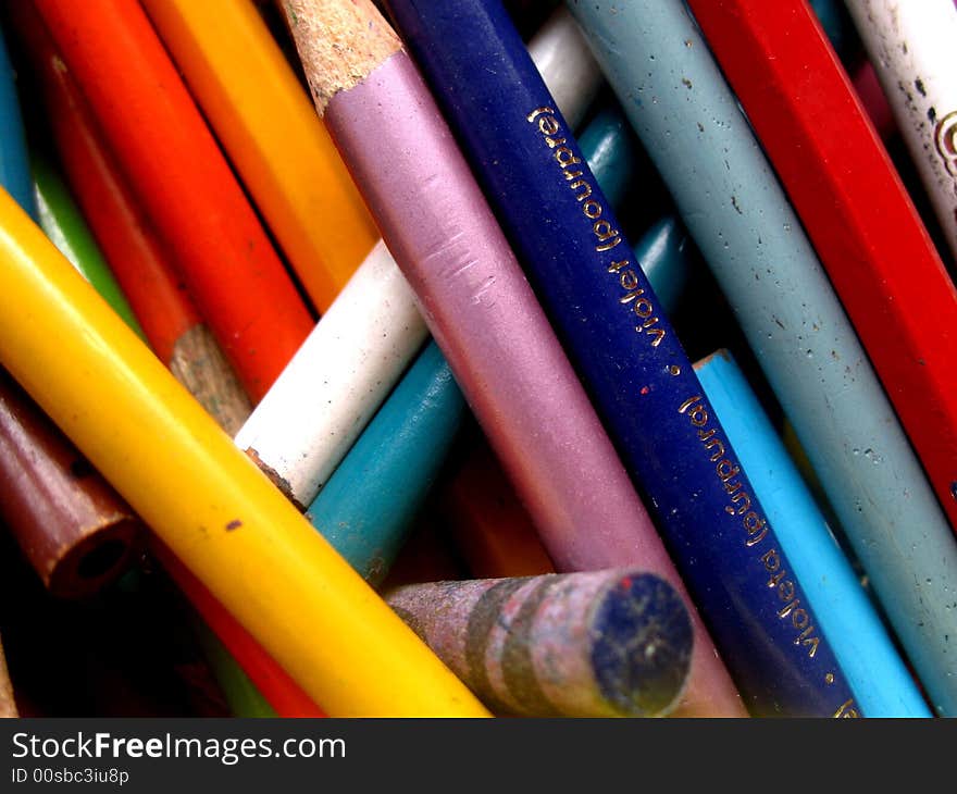 Jumbled up collection of old coloring pencils. Close up, full-frame shot