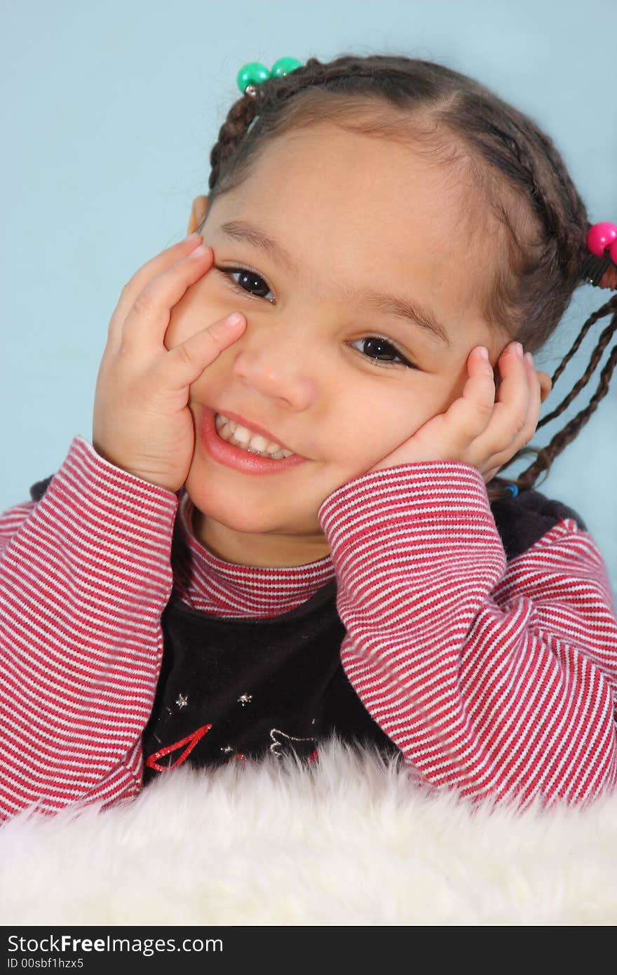 Portrait of a young happy girl posed with her hands on her cheeks. Portrait of a young happy girl posed with her hands on her cheeks