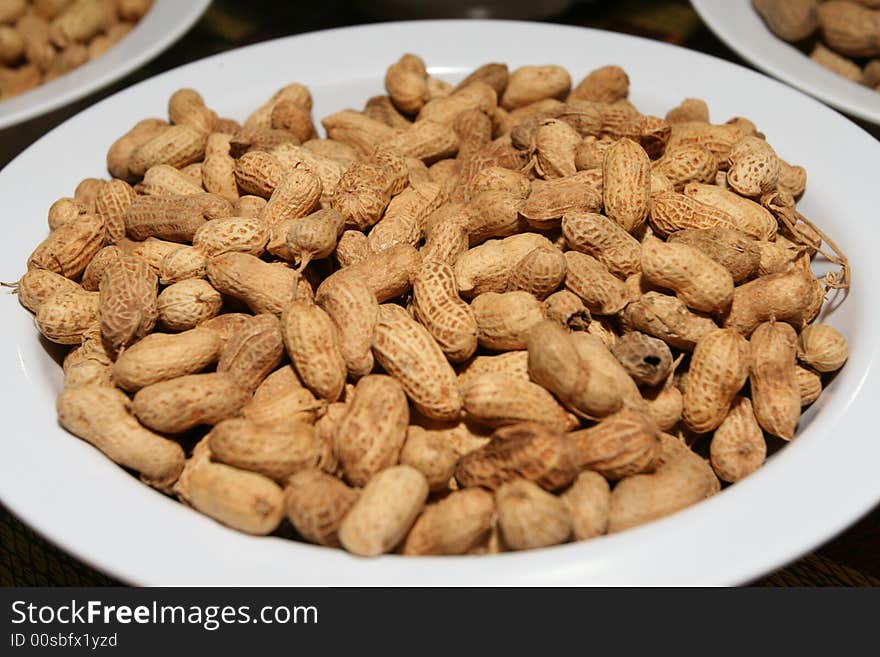 Peanuts snack on white background - shallow DOF, focus in the middle.