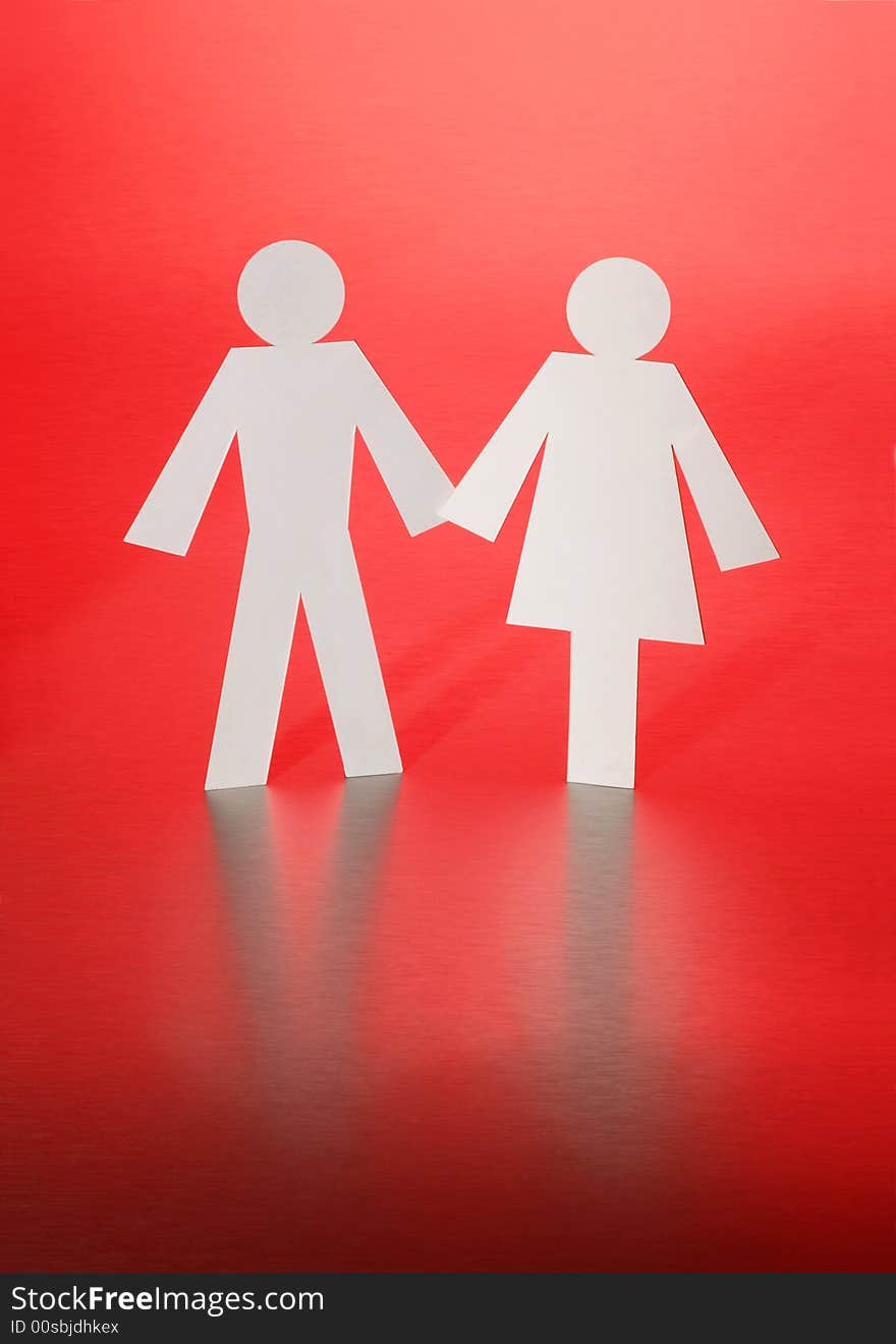 Paper cut-outs of a man and woman on a red background. Paper cut-outs of a man and woman on a red background