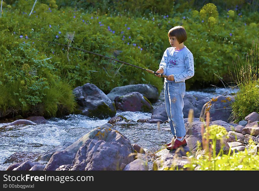 Girl it is caught trout in the mountain creek. Girl it is caught trout in the mountain creek