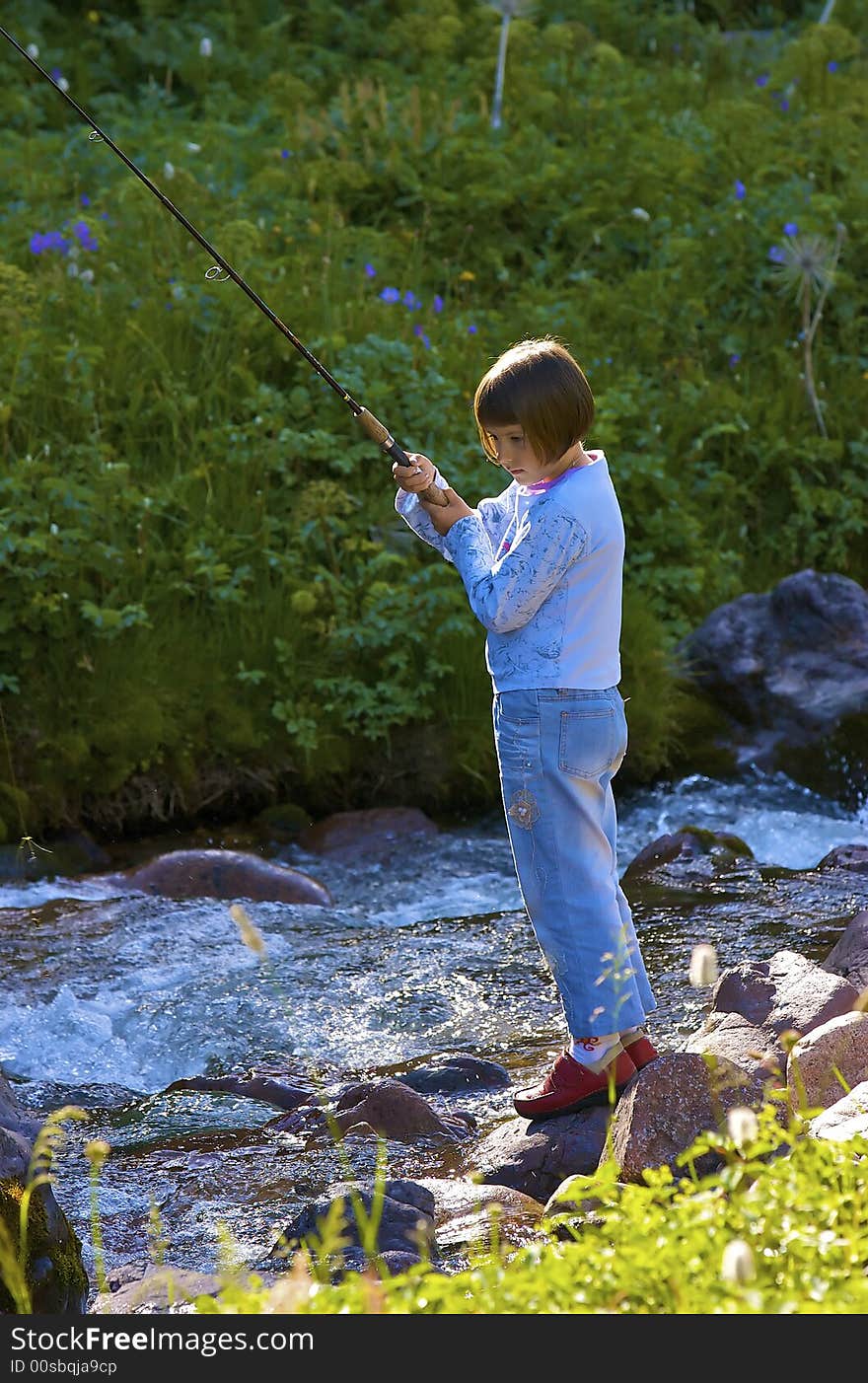 Girl it is caught trout in the mountain creek. Girl it is caught trout in the mountain creek