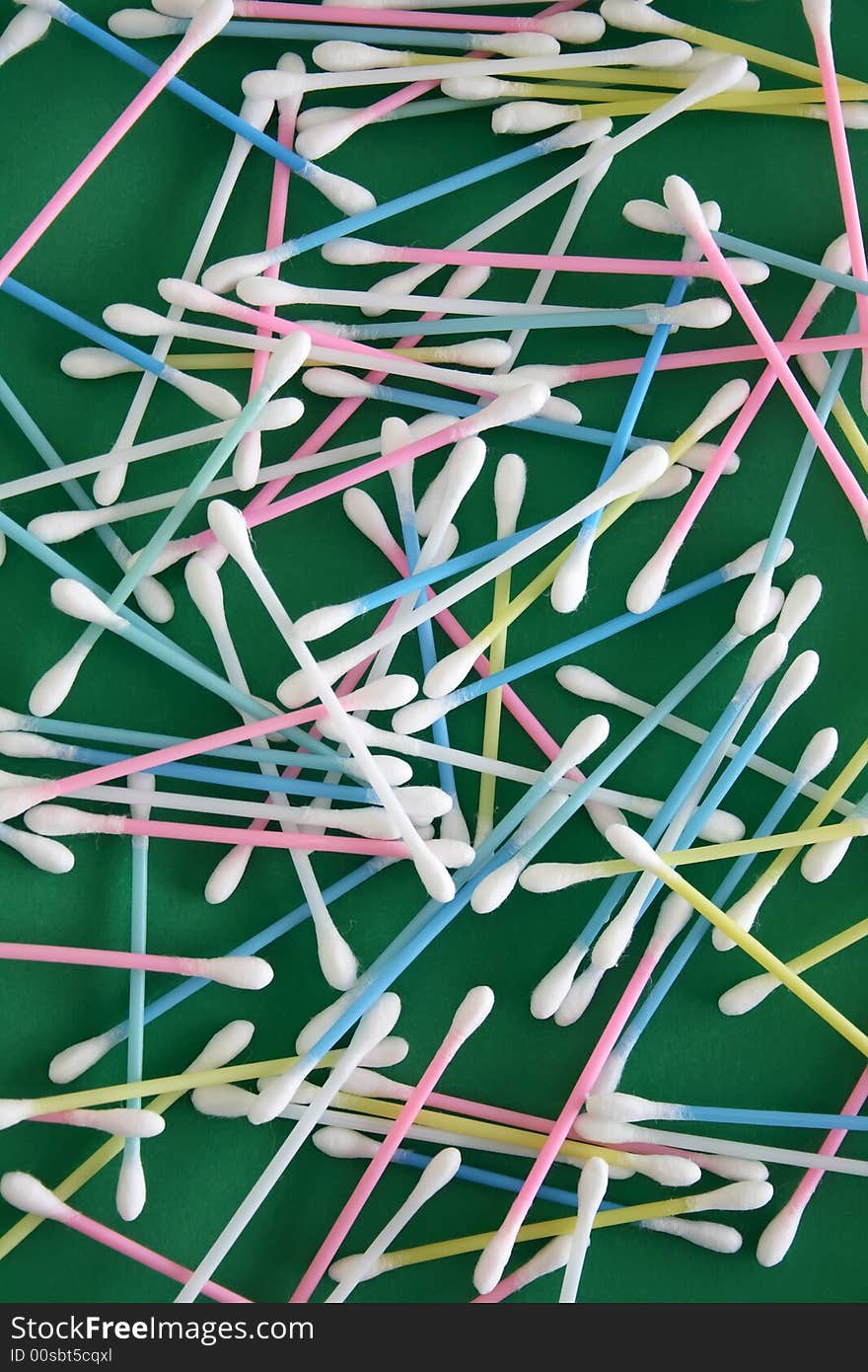 A pile of ear cleaners on a green background