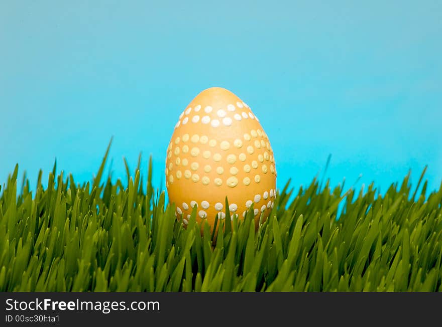 An image of a pastel easter egg in lush grass