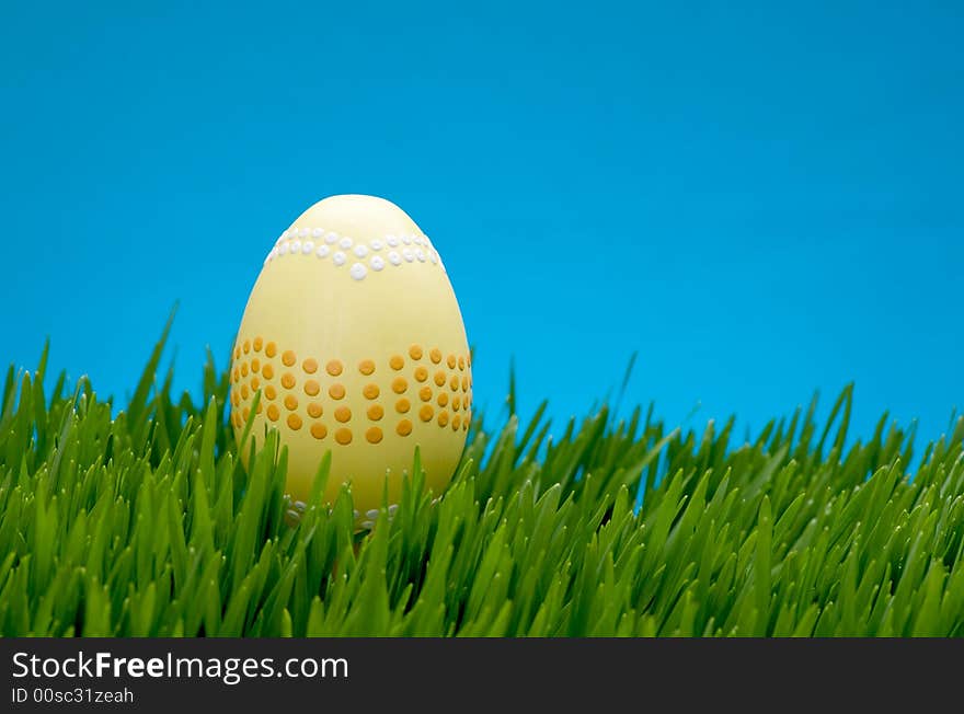 An image of a pastel easter egg in lush grass